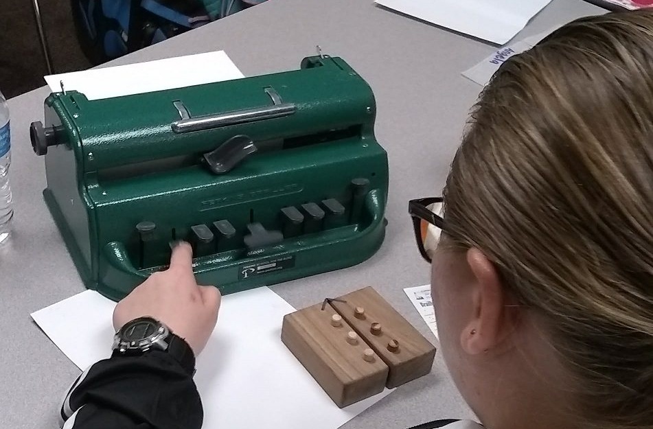 A student learns the braille cell using a swing cell and to write with a brailler
